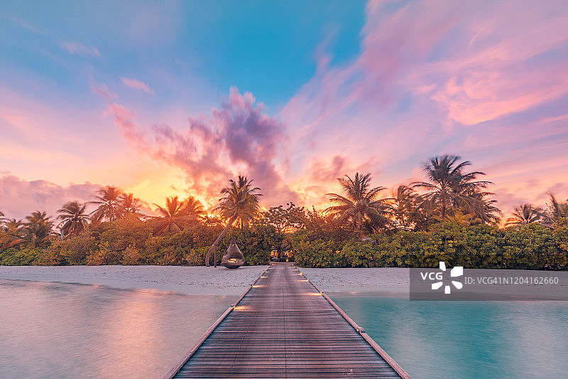 迷人的日落海滩：平静的海洋和热带风情图片素材