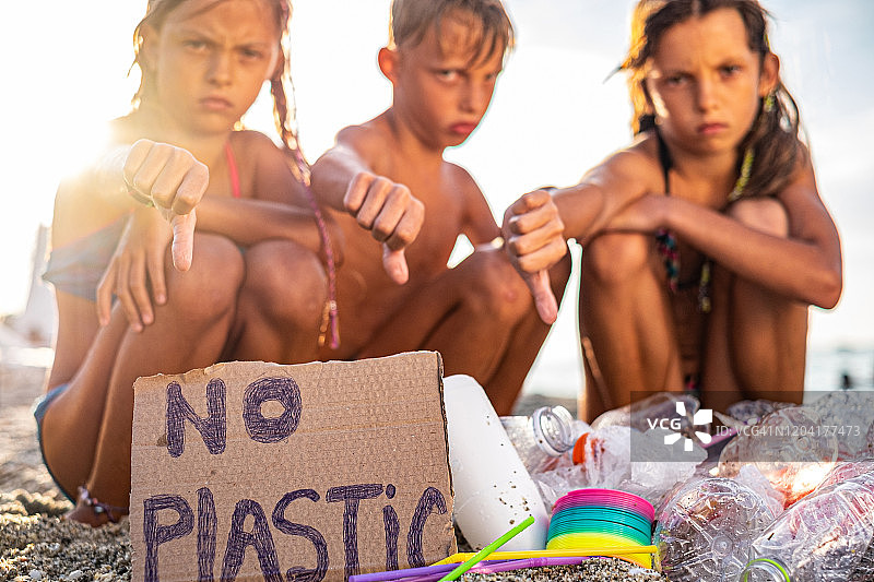 不开心的孩子们在海滩上发现大量塑料垃圾图片素材