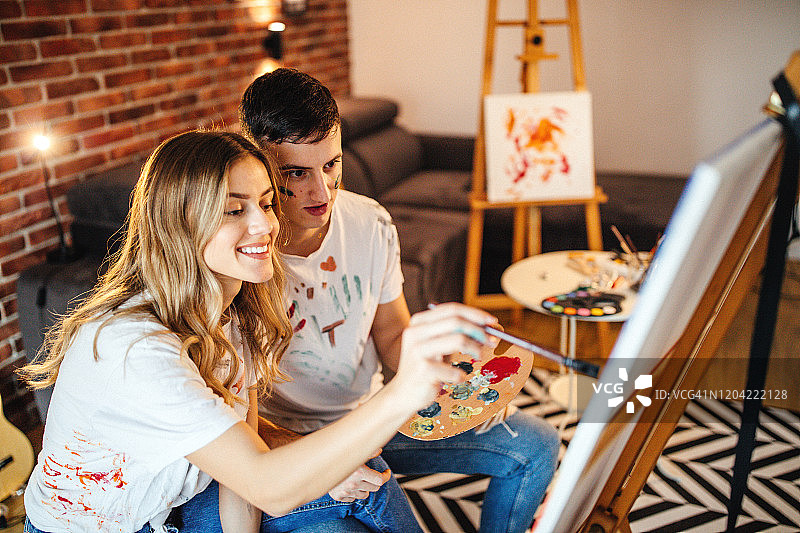 情侣在画布上绘画图片素材