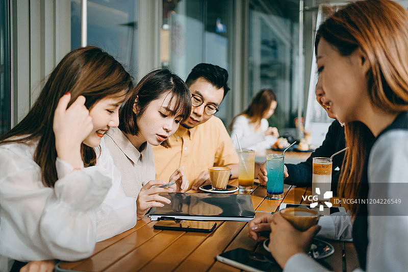 一群商务人士在户外合作处理商业项目，使用文件、智能手机和平板电脑图片素材