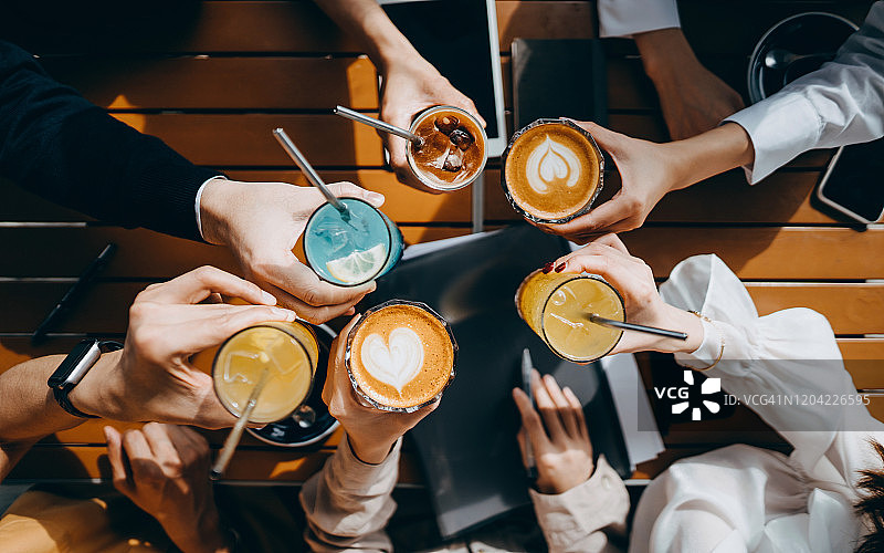 一群公司同事用可重复使用的不锈钢吸管喝饮料，庆祝下班后的顶角视图图片素材