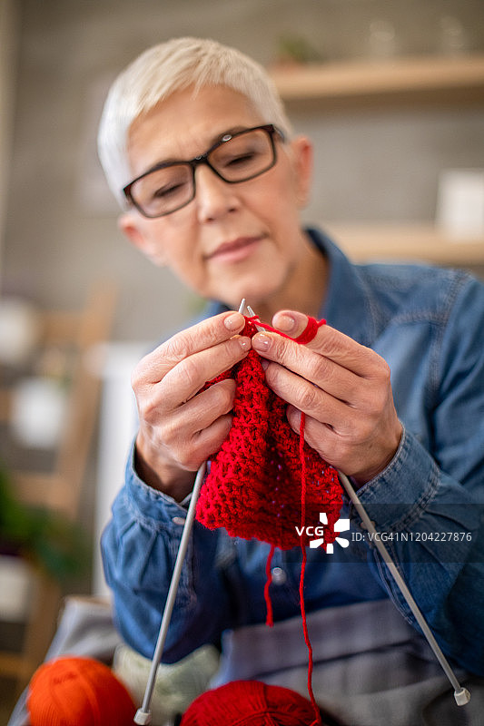 中年妇女正在为冬天制作一条温暖的围巾图片素材