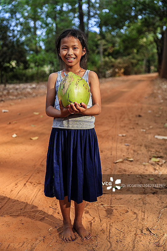 快乐的柬埔寨女孩拿着新鲜椰子，柬埔寨图片素材