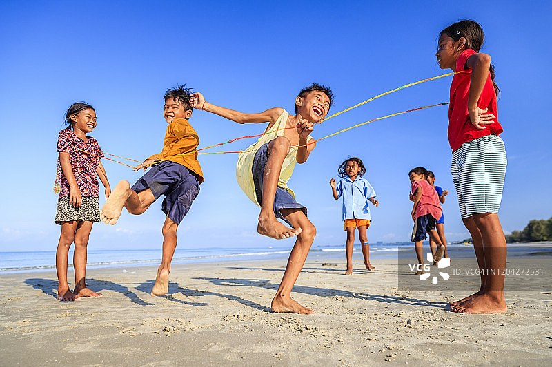 在海滩上玩跳橡皮筋的柬埔寨儿童图片素材