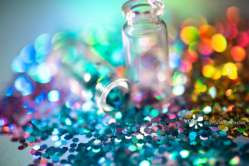 从瓶子里洒出的彩色闪光粉图片素材