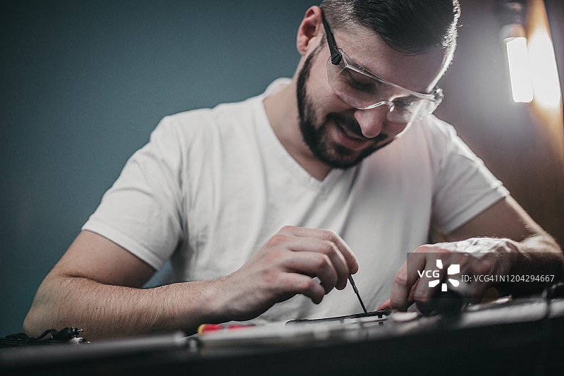 技术员仔细检查智能手机内部元件的完整性图片素材