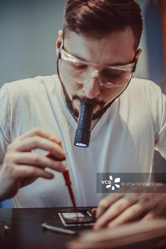 嘴里叼着手电筒的工人图片素材