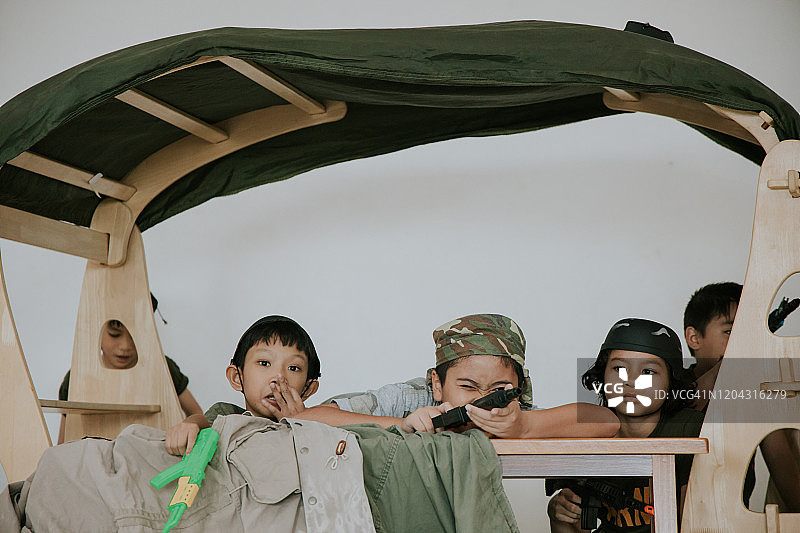 泰国可爱儿童在学校和朋友玩士兵游戏的角色扮演图片素材