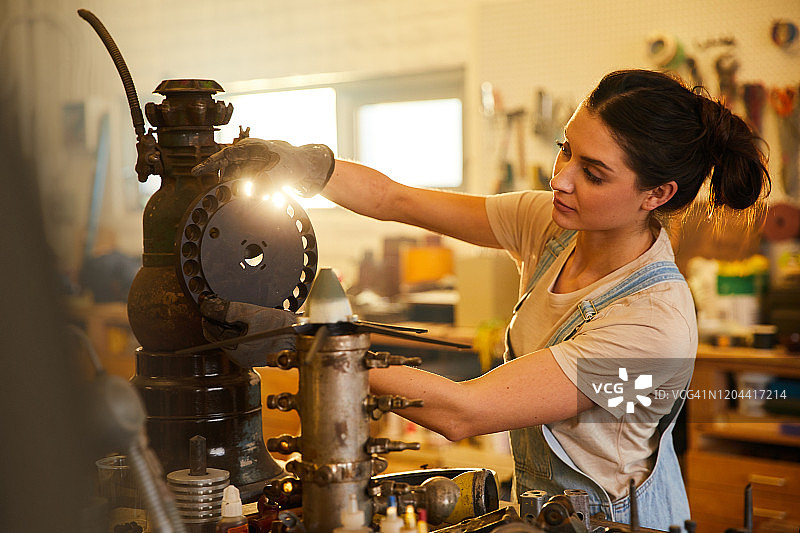 在木工车间工作台前的年轻女人图片素材