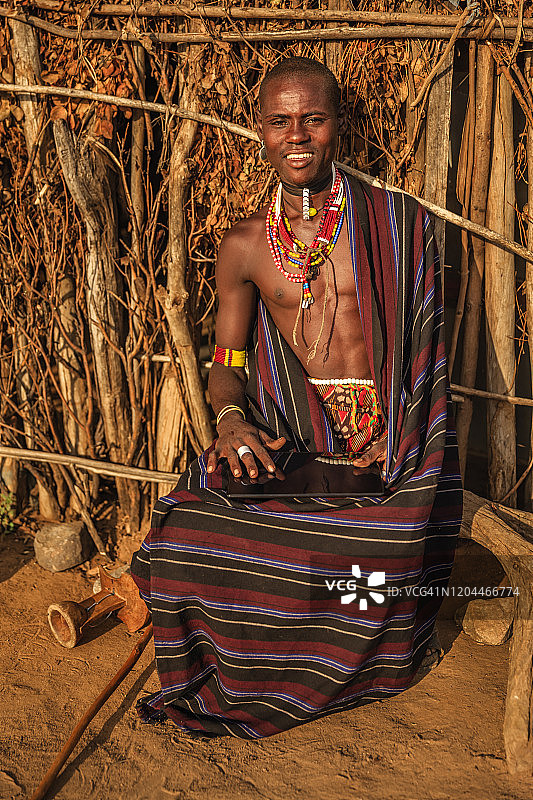 来自埃塞俄比亚埃尔博雷部落的年轻男子使用平板电脑图片素材