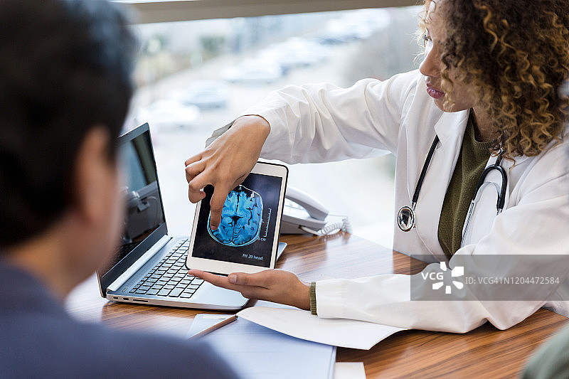 女医生向身份不明的男患者讲解脑部扫描结果图片素材