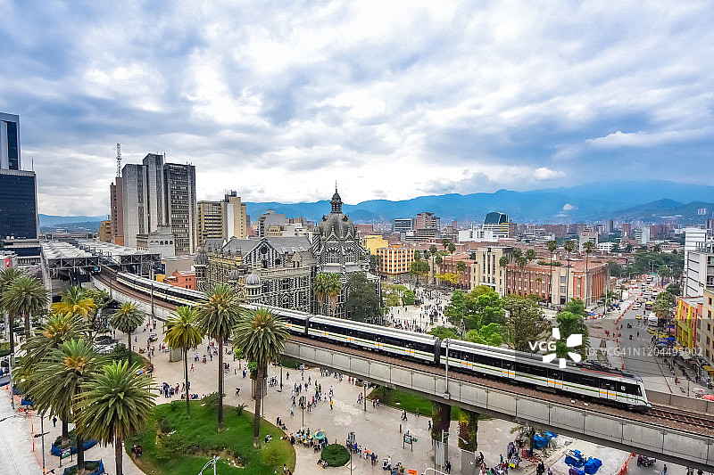 哥伦比亚麦德林城市景观高角度视图，前景为高架地铁列车图片素材