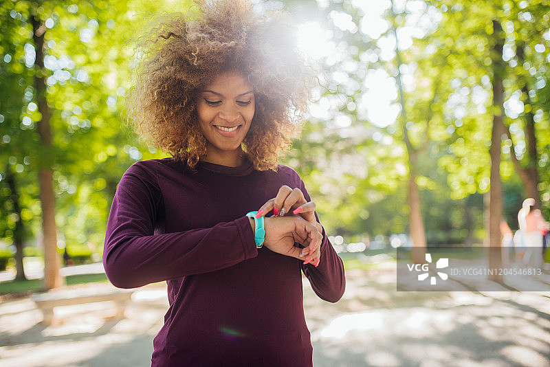女孩在公园慢跑后查看时间图片素材