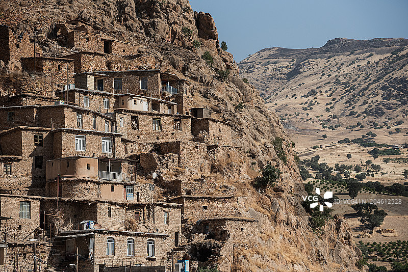 伊朗库尔德斯坦省帕朗安村陡峭岩石山崖上的房屋图片素材
