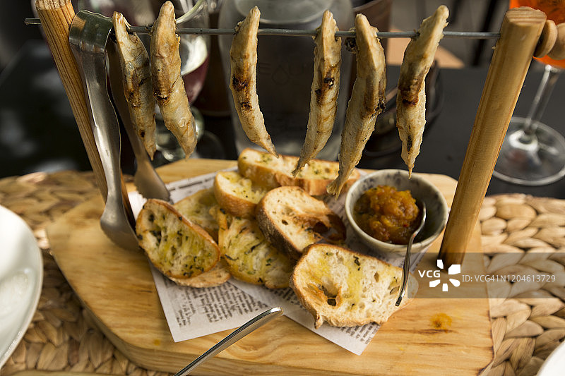 串在棍子上搭配面包的烤沙丁鱼图片素材