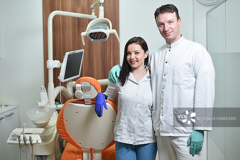 牙医诊所里快乐的牙医和牙科助理的肖像图片素材