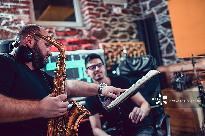 萨克斯演奏者向制作人请教特定乐段图片素材