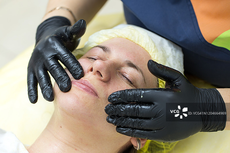 美容师按摩女性面部皮肤的手图片素材