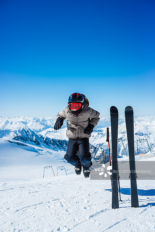 山顶上的年轻高山滑雪者图片素材