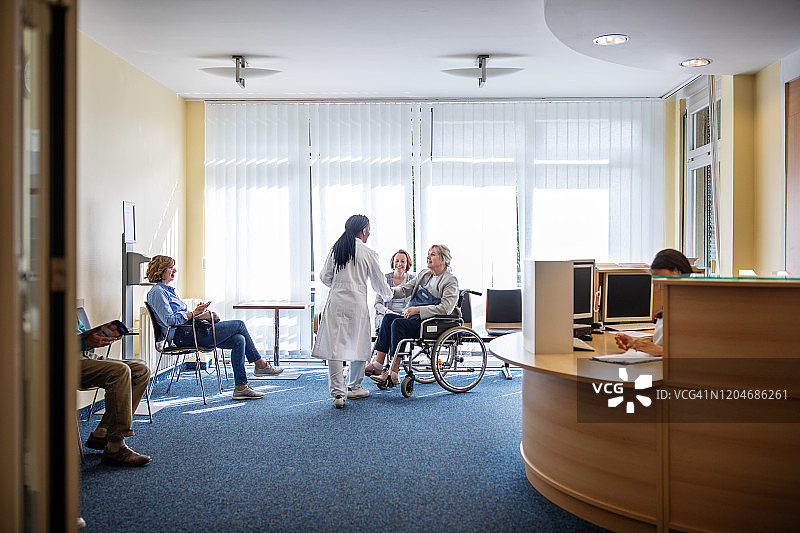 医生在医院候诊室问候残疾妇女图片素材