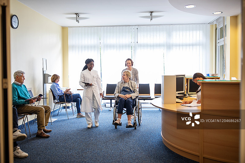 残疾妇女和女儿与医生同行图片素材