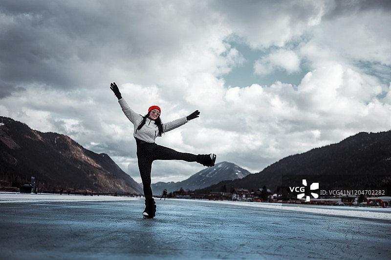 冬季，女人在冰冻的湖面上滑冰图片素材