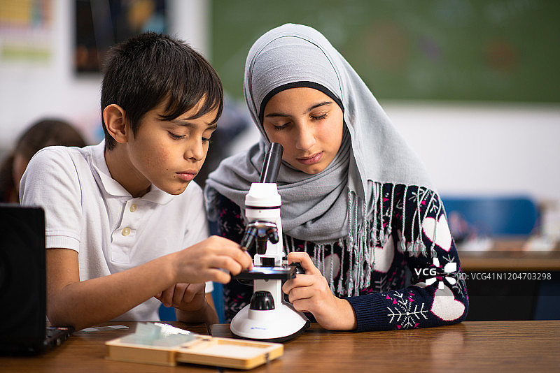 两名学生使用显微镜工作图片素材