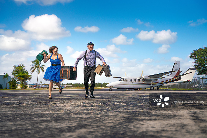 在机场停机坪上奔跑的复古情侣图片素材