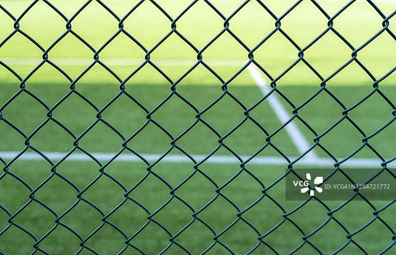 带刺铁丝网外的足球场图片素材