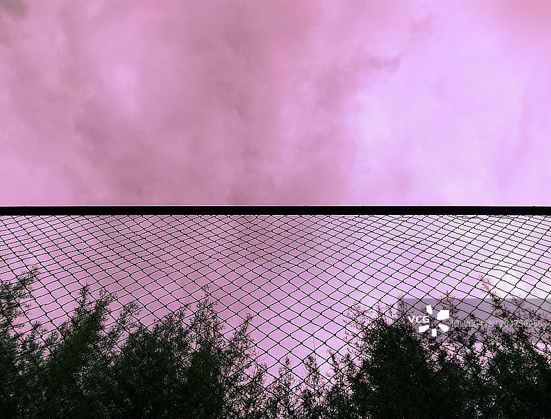 日落天空下的铁丝网围栏图片素材