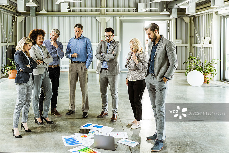 办公室里处理文件的混合年龄商业团队图片素材