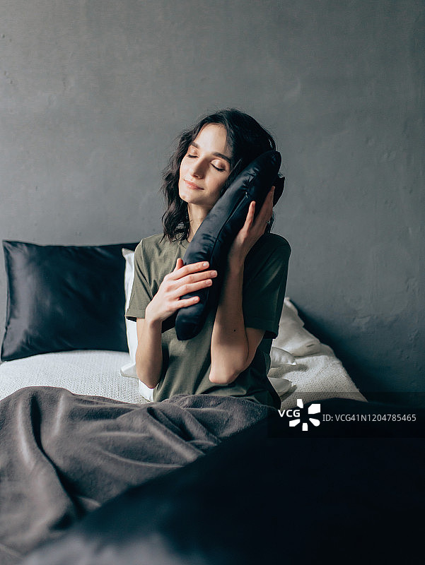 年轻快乐的女人抱着枕头图片素材