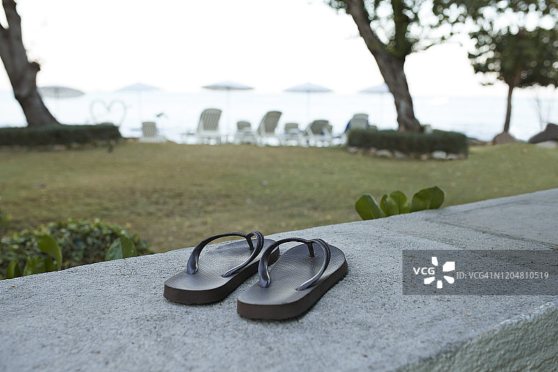 挡土墙上人字拖的特写图片素材