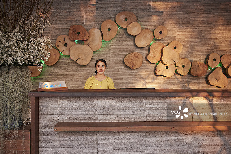 年轻女接待员站在酒店里图片素材