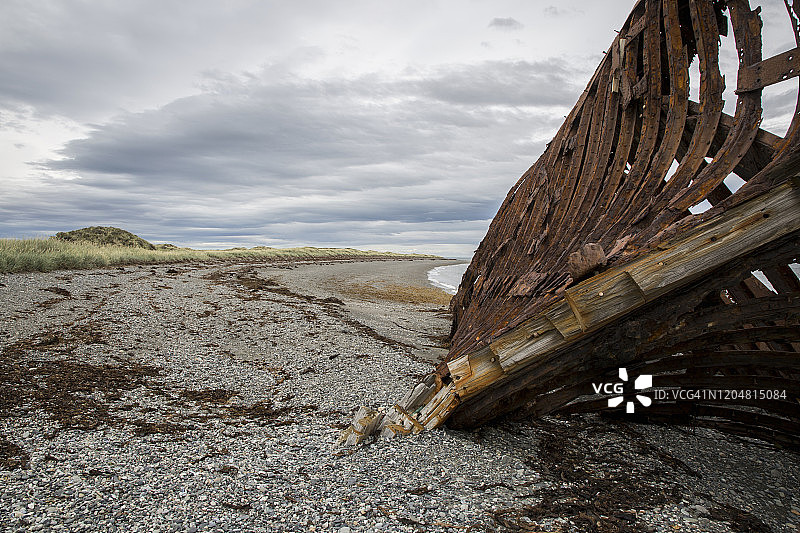 海滩上沉船生锈的金属肋骨和木制龙骨的抽象特写镜头图片素材