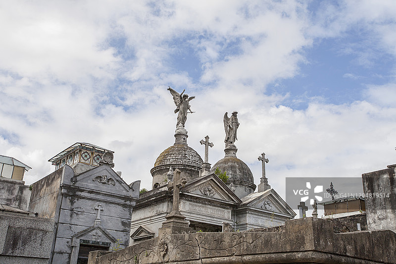 墓地古旧风化石像和地穴的蓝天白云低角度拍摄图片素材
