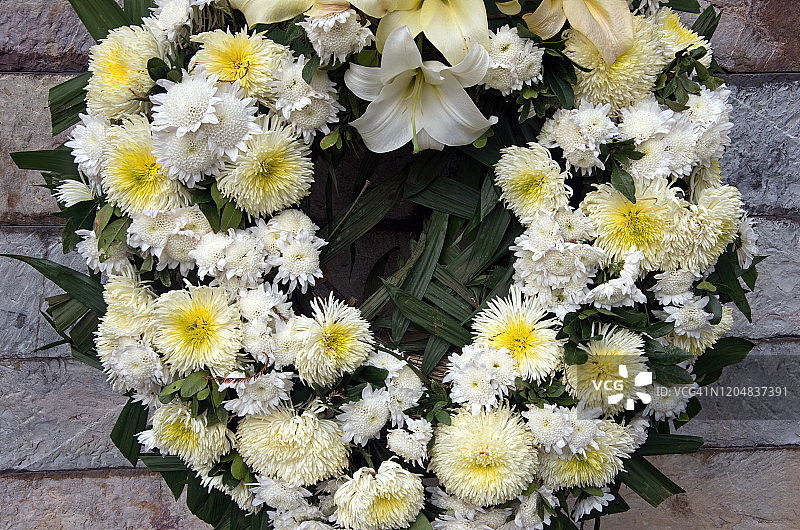 石墙上的白色花朵花环图片素材