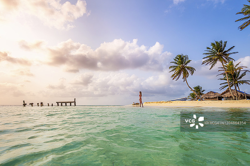 年轻女人在热带海滩欣赏日落，巴拿马圣布拉斯群岛图片素材