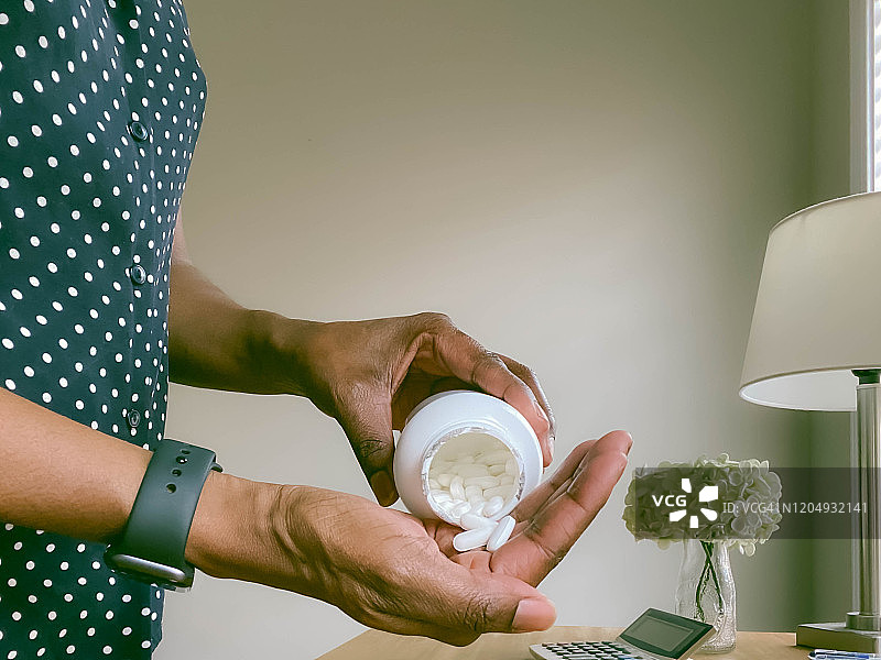 女人将药丸倒入掌心的特写图片素材