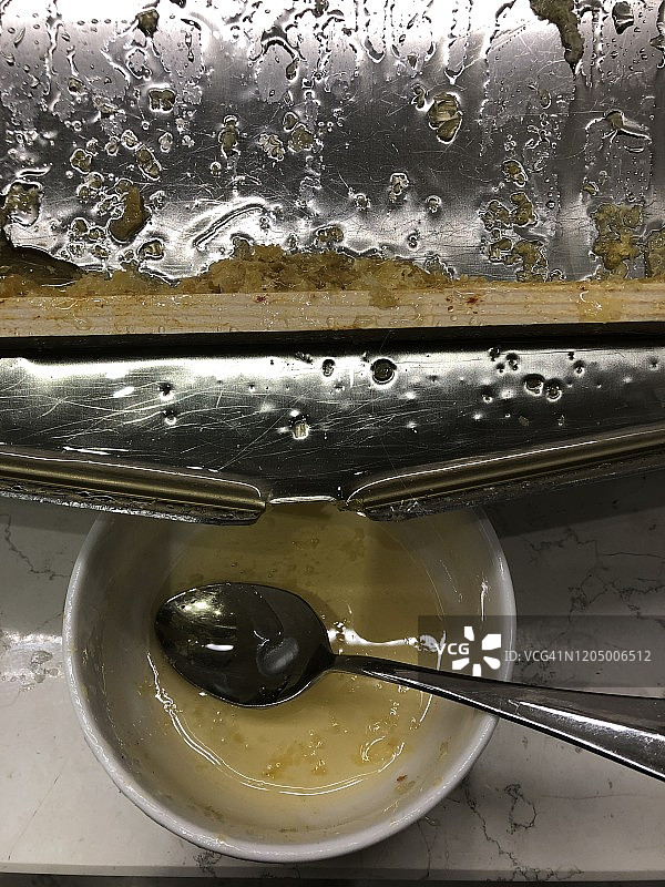 新鲜蜂巢中的蜂蜜滴入碗中，准备在意大利博洛尼亚的食物上食用图片素材