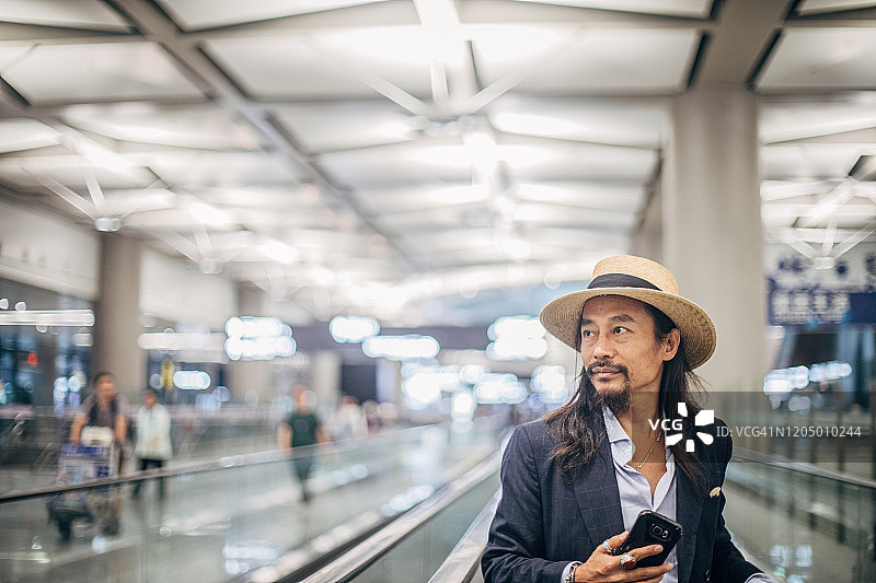 在机场发短信的时尚中年男人图片素材