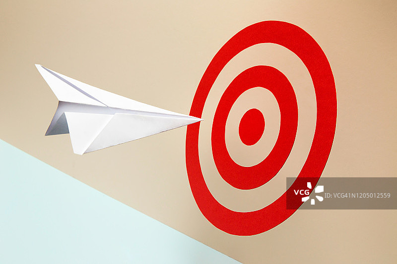 即将击中红色目标的纸飞机图片素材