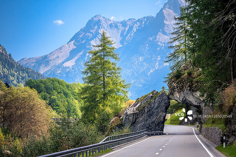 瑞士布雷加利亚斯坦帕村附近道路上的天然石拱门，秋季图片素材