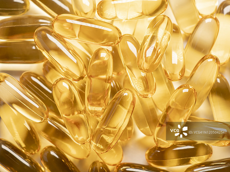 阳光下的金色鳕鱼肝油胶囊图片素材