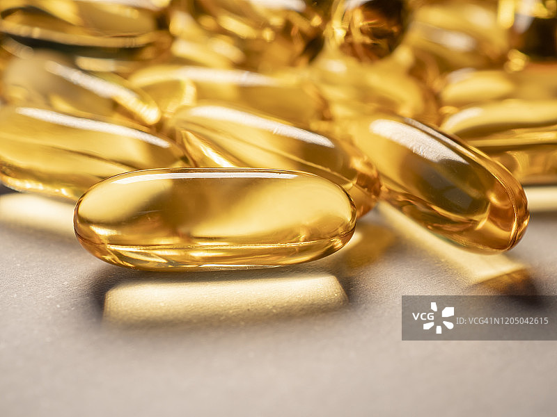 阳光下的金色鳕鱼肝油胶囊图片素材