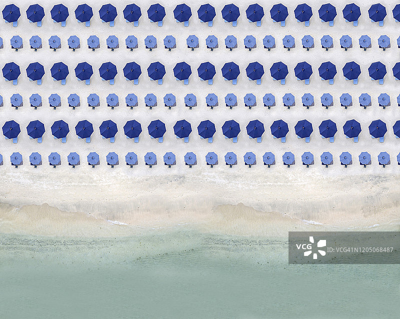 沙滩海岸线上蓝色海滩遮阳伞的航拍景色图片素材