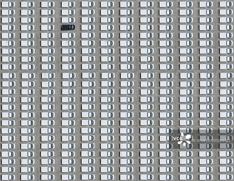 航拍：一辆黑色汽车停在清一色的白色汽车之间图片素材