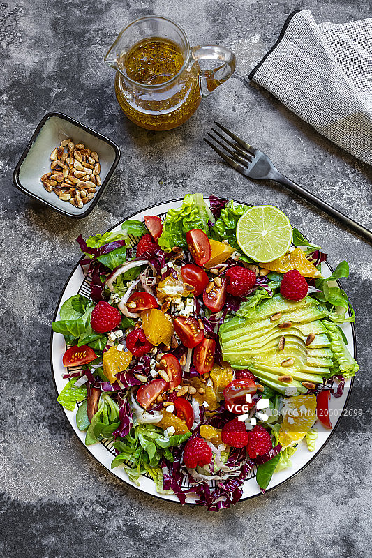 水果沙拉盘工作室照片，配羊肉生菜、菊苣、生菜心、鳄梨、番茄、松子、覆盆子、橙子、酸橙图片素材