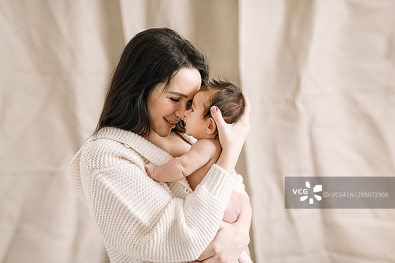 真实的白人母亲与新生婴儿，亚麻色调，自然色彩，母婴呵护，0-1个月，年轻，幸福，充满爱意的母亲怀抱婴儿，母性，女性气质，产后图片素材