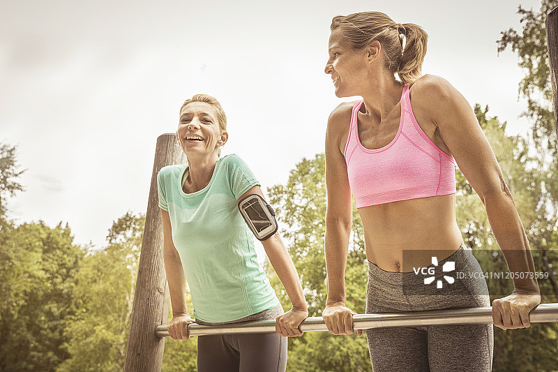 在公园高杠上锻炼的女人图片素材